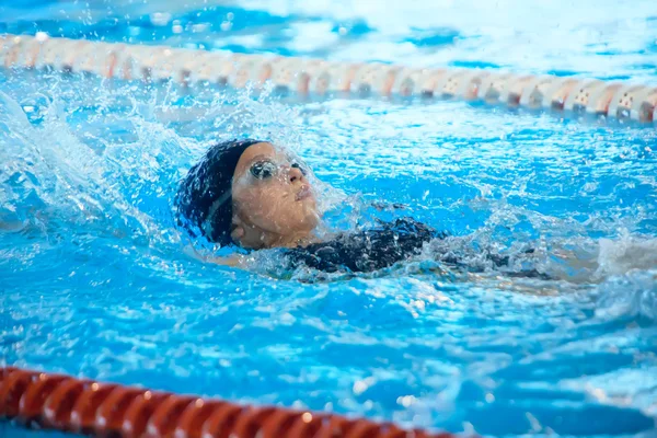 Ung kvinna simma ryggsim i poolen — Stockfoto