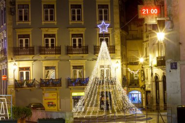 Geceleyin sokakta aydınlanan yılbaşı ağacı Portekiz 'in eski bir kasabasının caddesinde