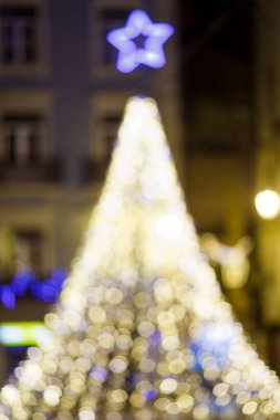 Geceleyin sokakta aydınlanan yılbaşı ağacı Portekiz 'in eski bir kasabasının caddesinde