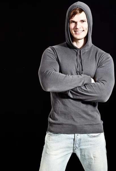 Joven atractivo hombre feliz con suéter gris con capucha —  Fotos de Stock