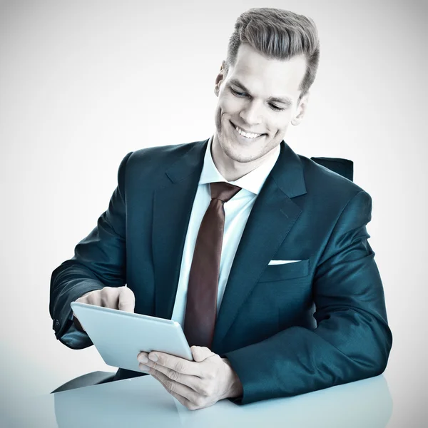 Glücklicher junger Geschäftsmann, der mit einem modernen Tablet-Computer arbeitet — Stockfoto