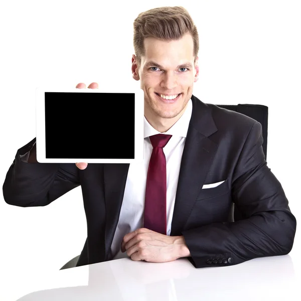 Pohledný mladý podnikatel ukazující tabletu výpočetní — Stock fotografie