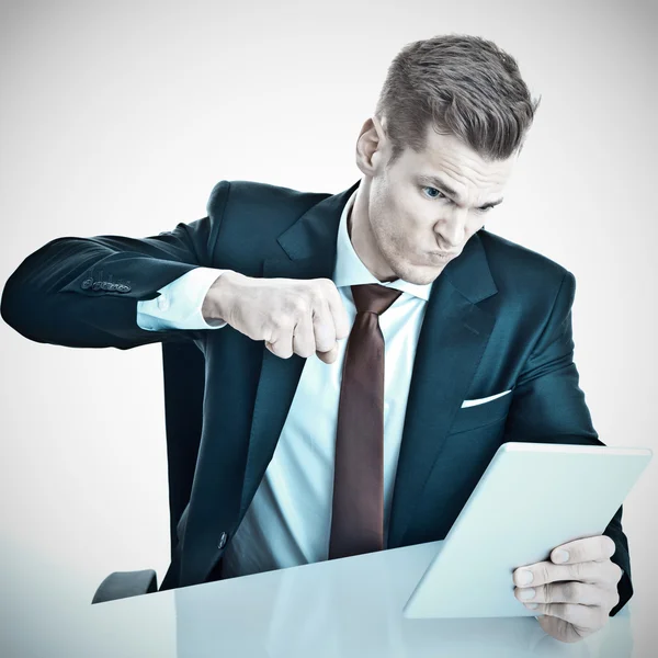 Boos jonge zakenman ponsen zijn tablet pc met zijn fis — Stockfoto
