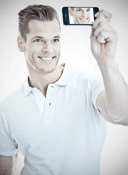 Cheerful young man taking a selfie with a modern smartphone — Stock Photo, Image