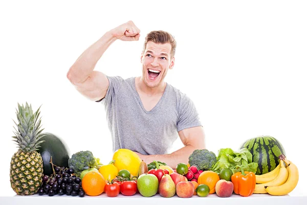 Successful Diet - Handsome muscular man sitting behind a row of — Stock Photo, Image