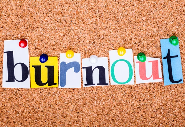 The word Burnout in cut out magazine letters pinned to a cork no — Stock Photo, Image