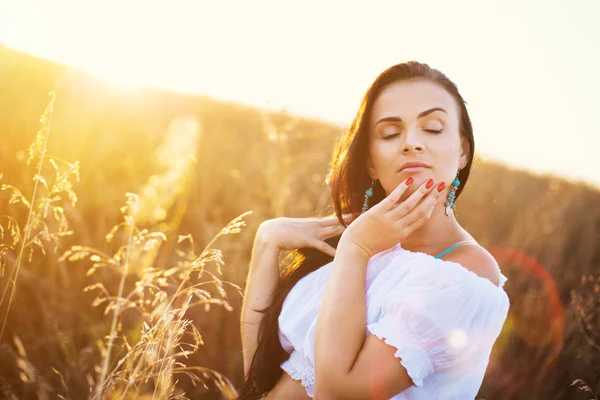 Mulher bonita no campo ao pôr do sol — Fotografia de Stock