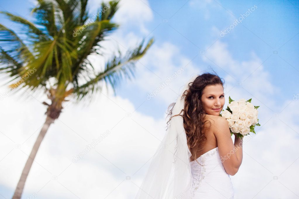 Beautiful caucasian bride posing at a tropical beach