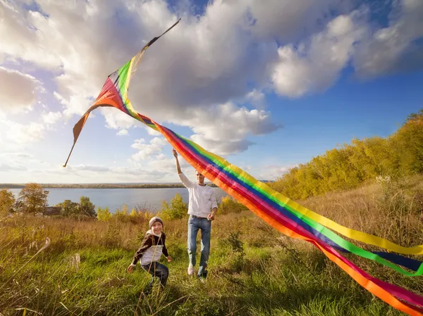 Padre con hijo en otoño jugando con cometa — Foto de Stock