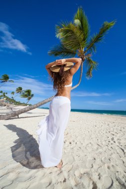 Sahilde denize bakarak şapkalı kız