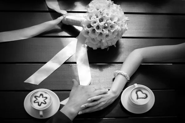 Mãos de homem e mulher e xícaras de café na mesa, preto e branco — Fotografia de Stock