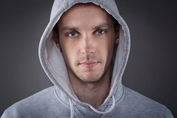 Closeup of young man with hand on head on gray background — Stock Photo, Image