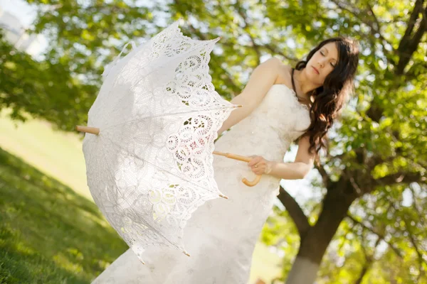 Bride is holding a cookie lace umbrella, focus point on the umbrella — Stock Photo, Image
