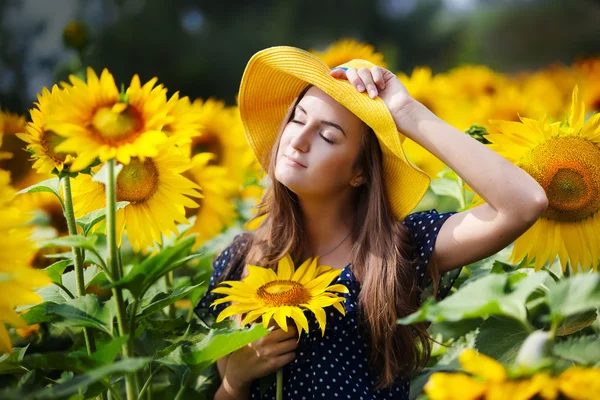 Bella giovane donna su un campo di girasoli — Foto Stock