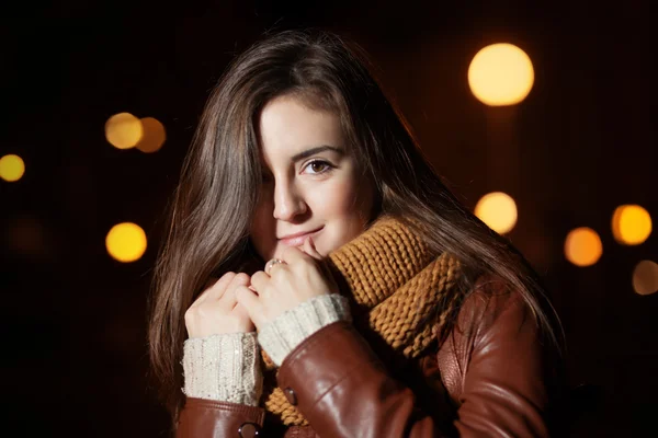 Портрет девушки в шарфе на фоне ночного города — стоковое фото