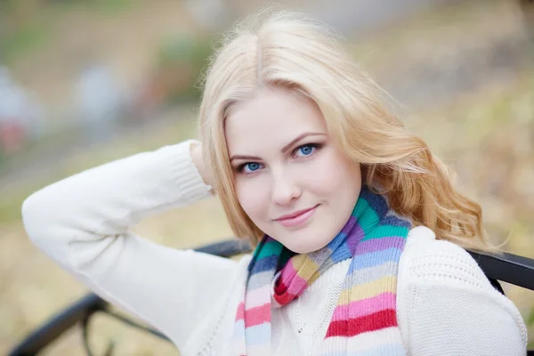 Pretty blond girl in a striped scarf, close-up — Stock Photo, Image