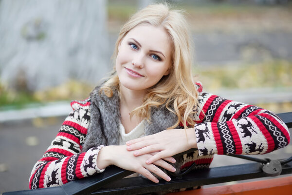 Young blonde girl in cardigan with a traditional Celtic ornament