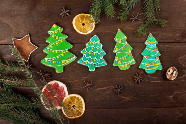 Pão de gengibre-árvores de Natal com esmalte colorido no fundo de madeira — Fotografia de Stock