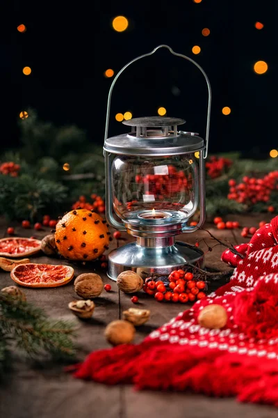 Burning lantern christmas scarf and fir tree branches on a wooden background — Stock Photo, Image