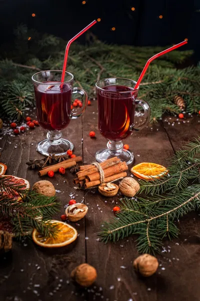 Ramas de abeto, dos copas de vino caliente sobre una mesa de madera — Foto de Stock