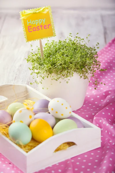 Huevos de Pascua, hierba verde, sobre una mesa blanca — Foto de Stock