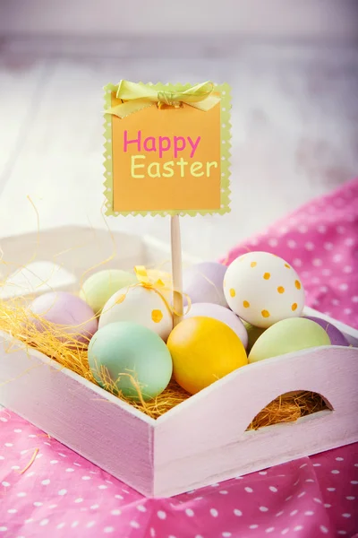 Bricka med färgglad påsk ägg på vita träbord — Stockfoto
