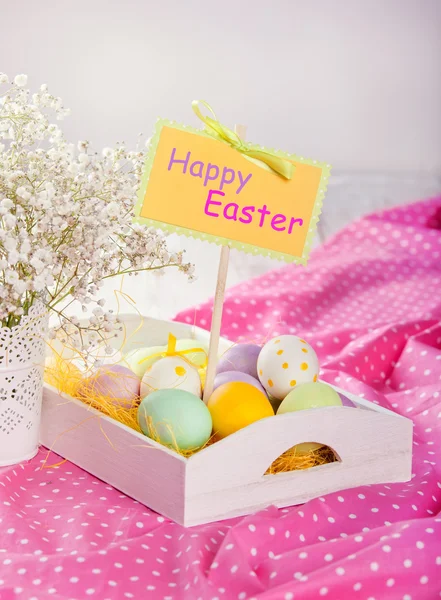 Tray with colorful Easter eggs on a pink tablecloth — Stock Photo, Image