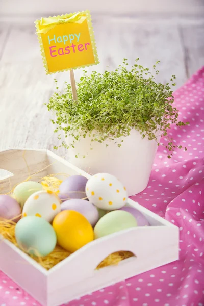 Пасхальные яйца, зеленая трава, на белом столе — стоковое фото