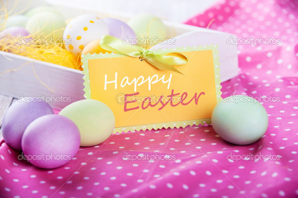 Easter eggs on a pink tablecloth, closeup. Space for text