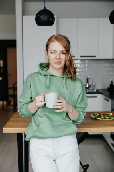 Portré egy gyönyörű fiatal vörös hajú nőről a konyhában — Stock Fotó