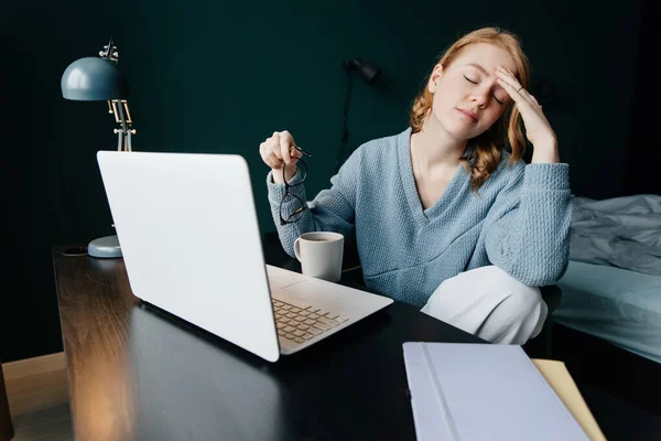 Cansada mujer caucásica trabajando hasta tarde en la noche utilizando el ordenador portátil en su dormitorio Imágenes De Stock Sin Royalties Gratis