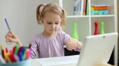 Küçük kız internet ve tablet kullanarak resim yapmayı öğreniyor.