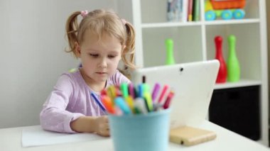 Küçük kız internet ve tablet kullanarak resim yapmayı öğreniyor.