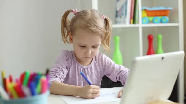 Маленька дівчинка вчиться малювати онлайн за допомогою Інтернету і планшетного комп'ютера — стокове відео