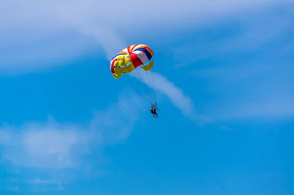 Mensen op parachute in de blauwe hemel — Stockfoto