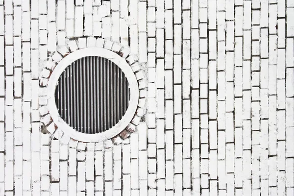 Grade de vias aéreas na parede de tijolo pintada de branco — Fotografia de Stock