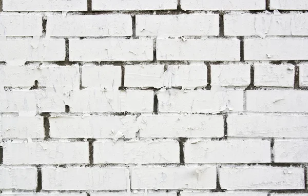 Morceau de papier déchiré sur le mur de brique peint en blanc — Photo