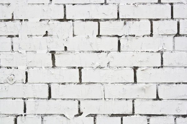 Morceau de papier déchiré sur le mur de brique peint en blanc — Photo