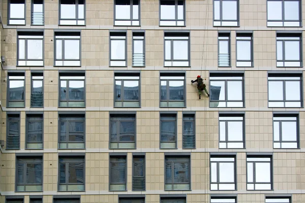 Limpador-homem parede de lavagem em altura, arranha-céus apartamento moderno — Fotografia de Stock