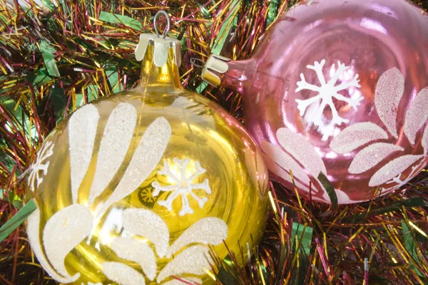 Cristmas card on tinsel background with two baubles purple and yellow — Stock Photo, Image