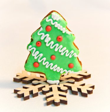 Noel zencefil çerezleri üzerinde beyaz bir arka plan üzerinde ahşap bir kar tanesi