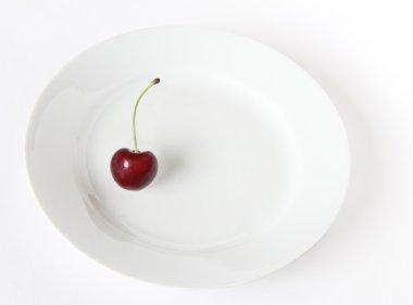 izole beyaz bir arka plan üzerinde beyaz bir plaka üzerinde bir kiraz