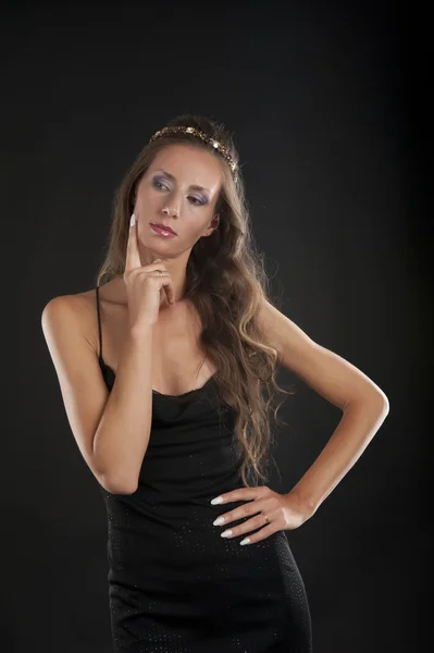 Een jonge vrouw in een zwarte jurk — Stockfoto