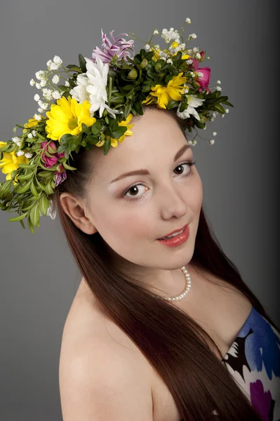 Meisje met een krans van bloemen — Stockfoto