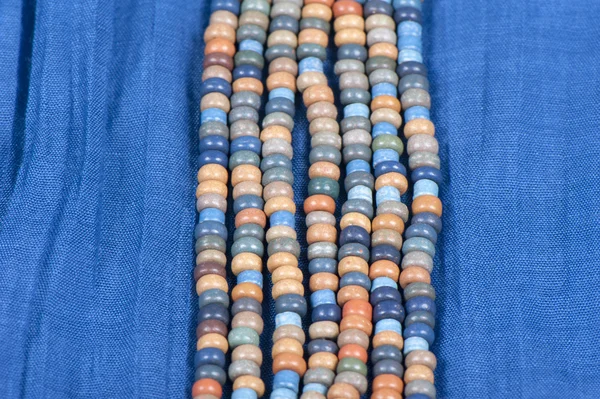 Blauer Stoff mit farbigen Perlen — Stockfoto