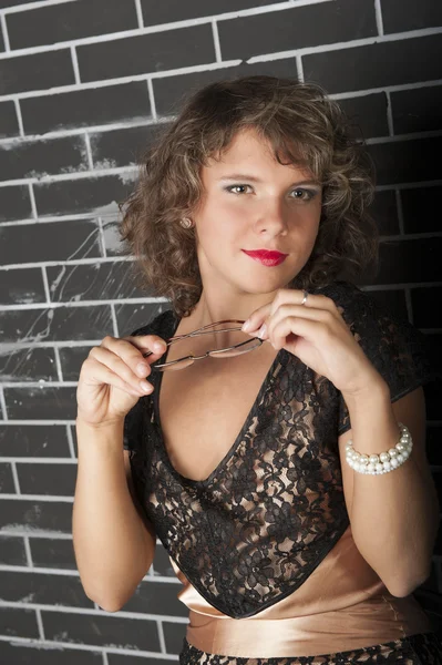 Curly girl with glasses in black dress — Stock Photo, Image