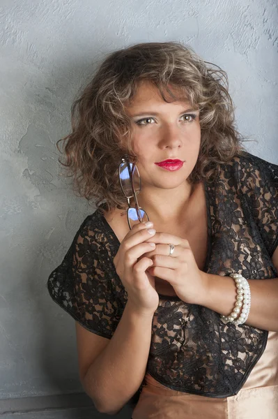 Curly girl with glasses in black dress Stock Image