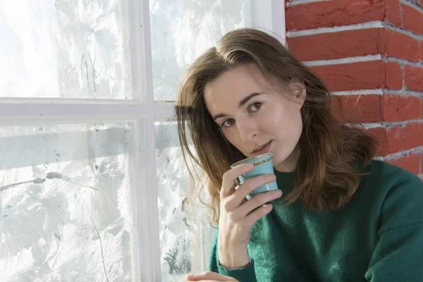 Jonge vrouw bij het raam winter — Stockfoto
