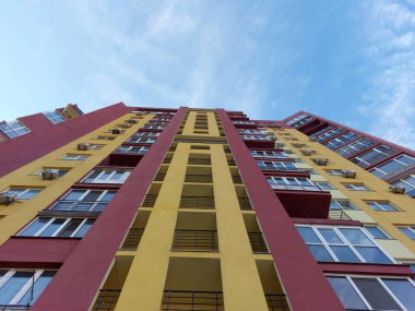 Mavi gökyüzüne karşı parlak bir yaz güneşli bir günde güzel renklere sahip bir konut modern yüksek katlı kentsel evin Cephe