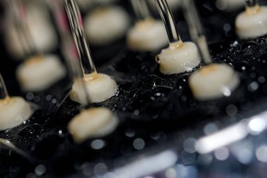 El banyosu başlığı, deliklerden akan su püskürtüleriyle yakın çekim makro fotoğrafçılık, kısa pozlama.